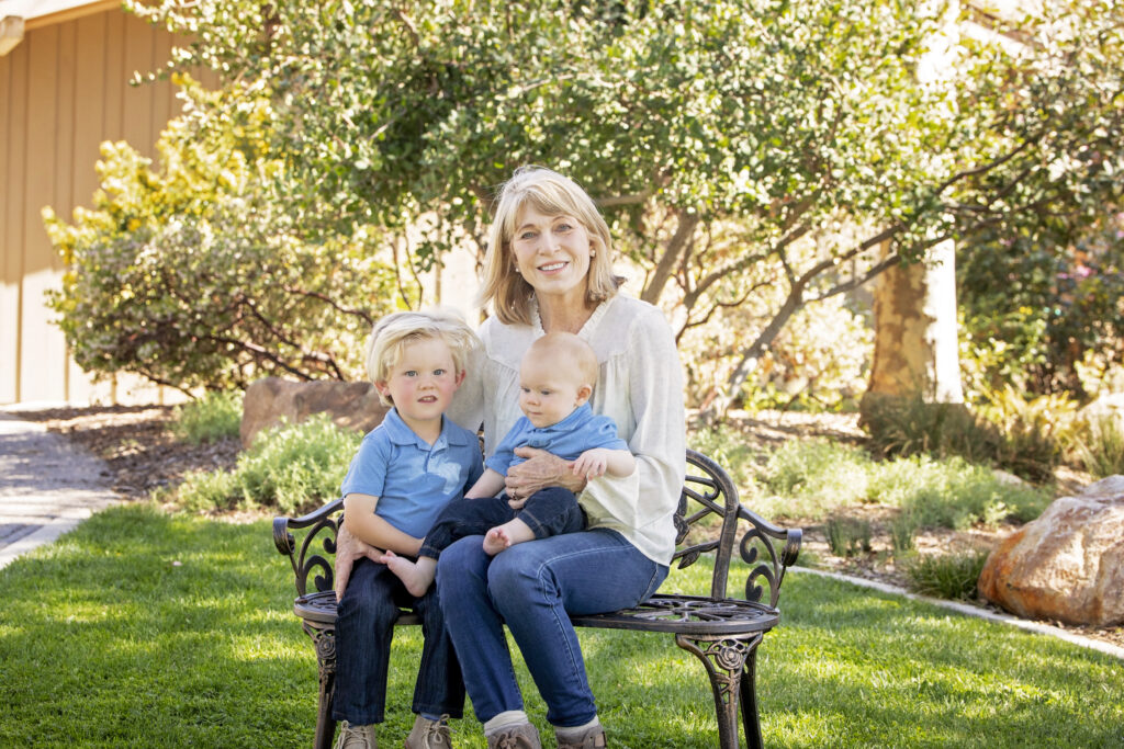 grandma sitting on a bench with her grandsons at the Atascadero Lake Park