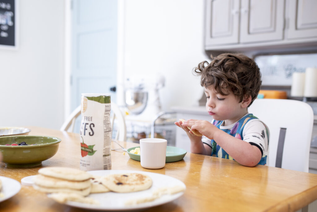 young boy eating breakfast at the table