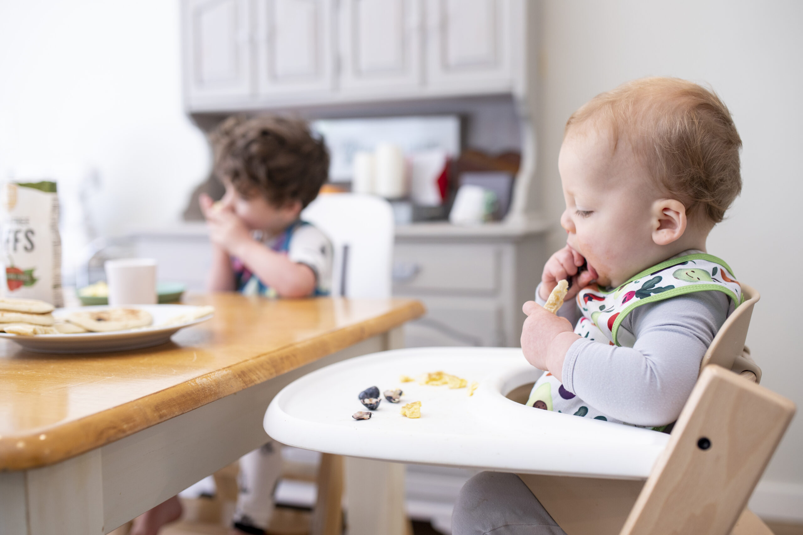 toddler eating breakfast in his high chair