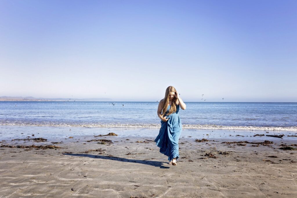 Senior girl walking away from the ocean at the beach