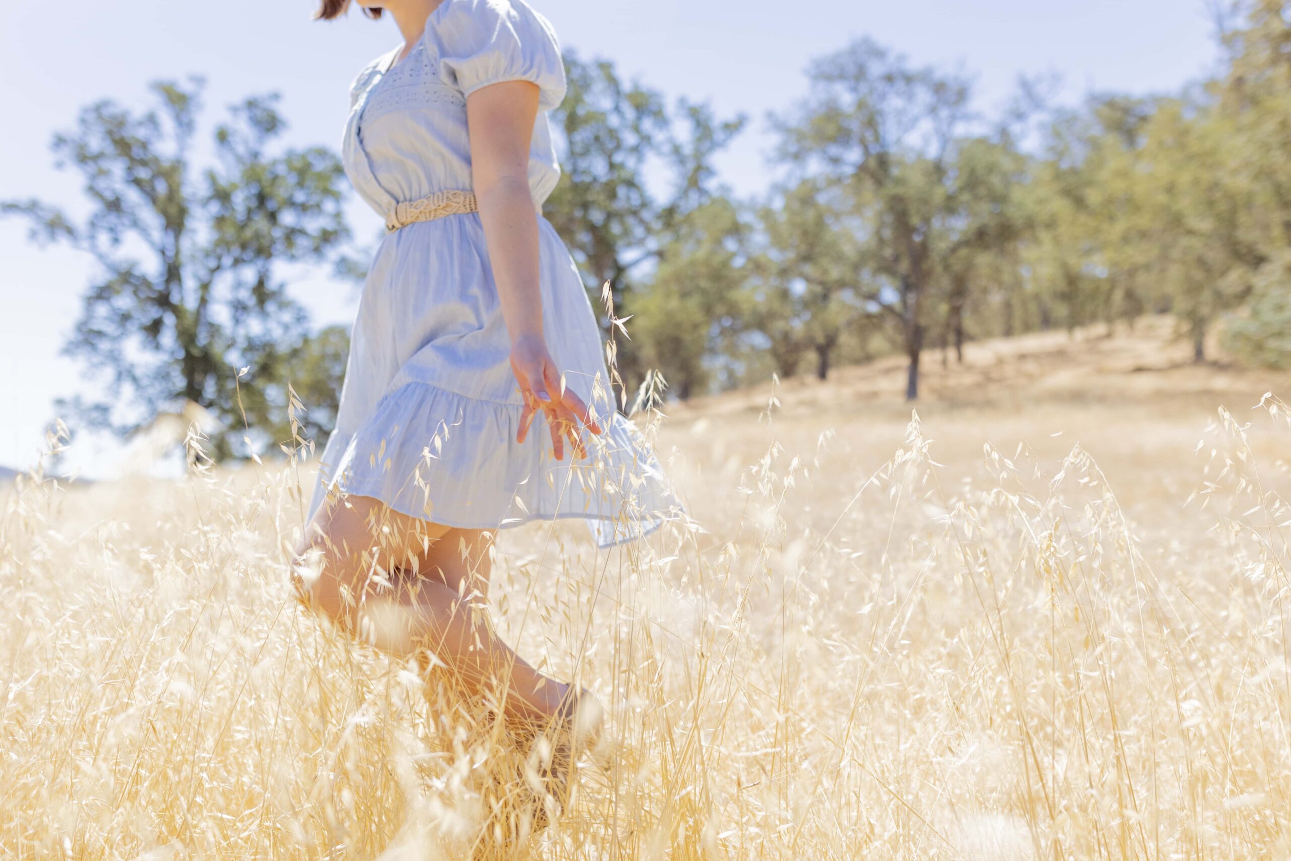 Senior girl walking through a grassy field
