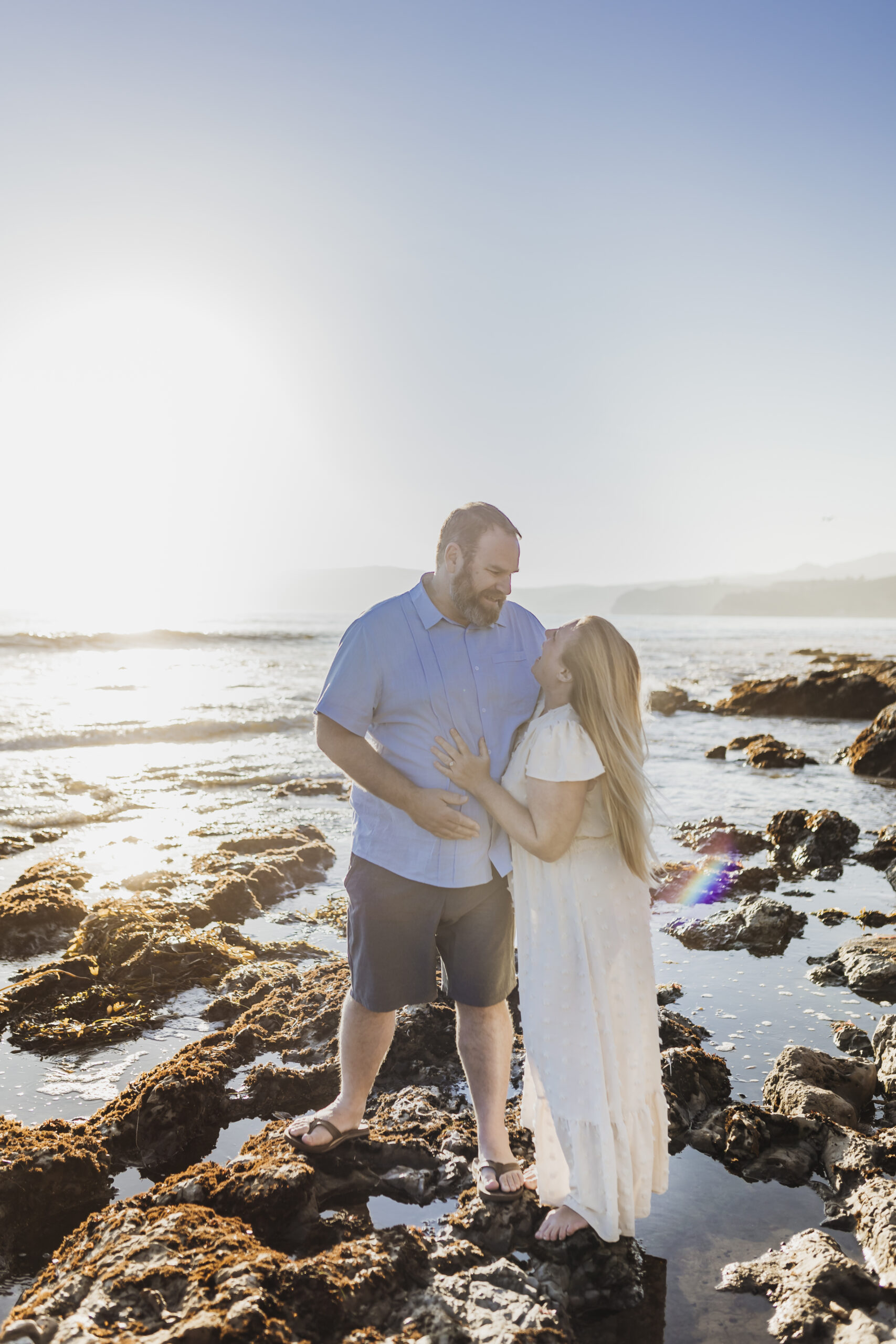 husband and wife embrace on the beach