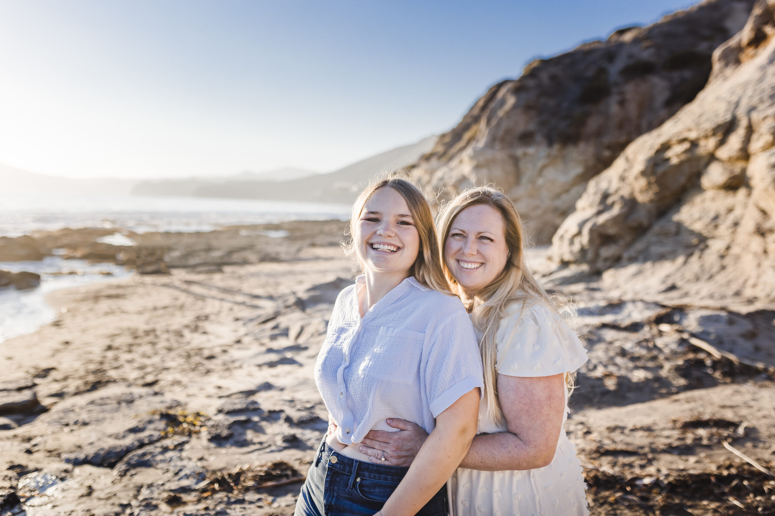 mother hugging her daughter on the beach