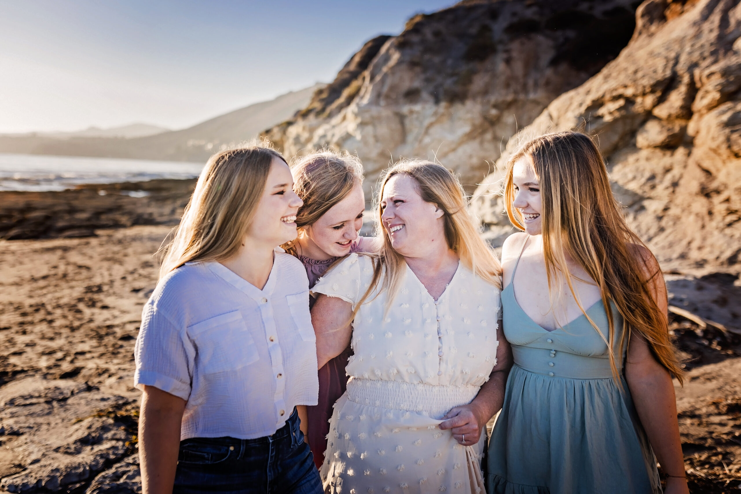 mother and three daughters look at each other while at the beach