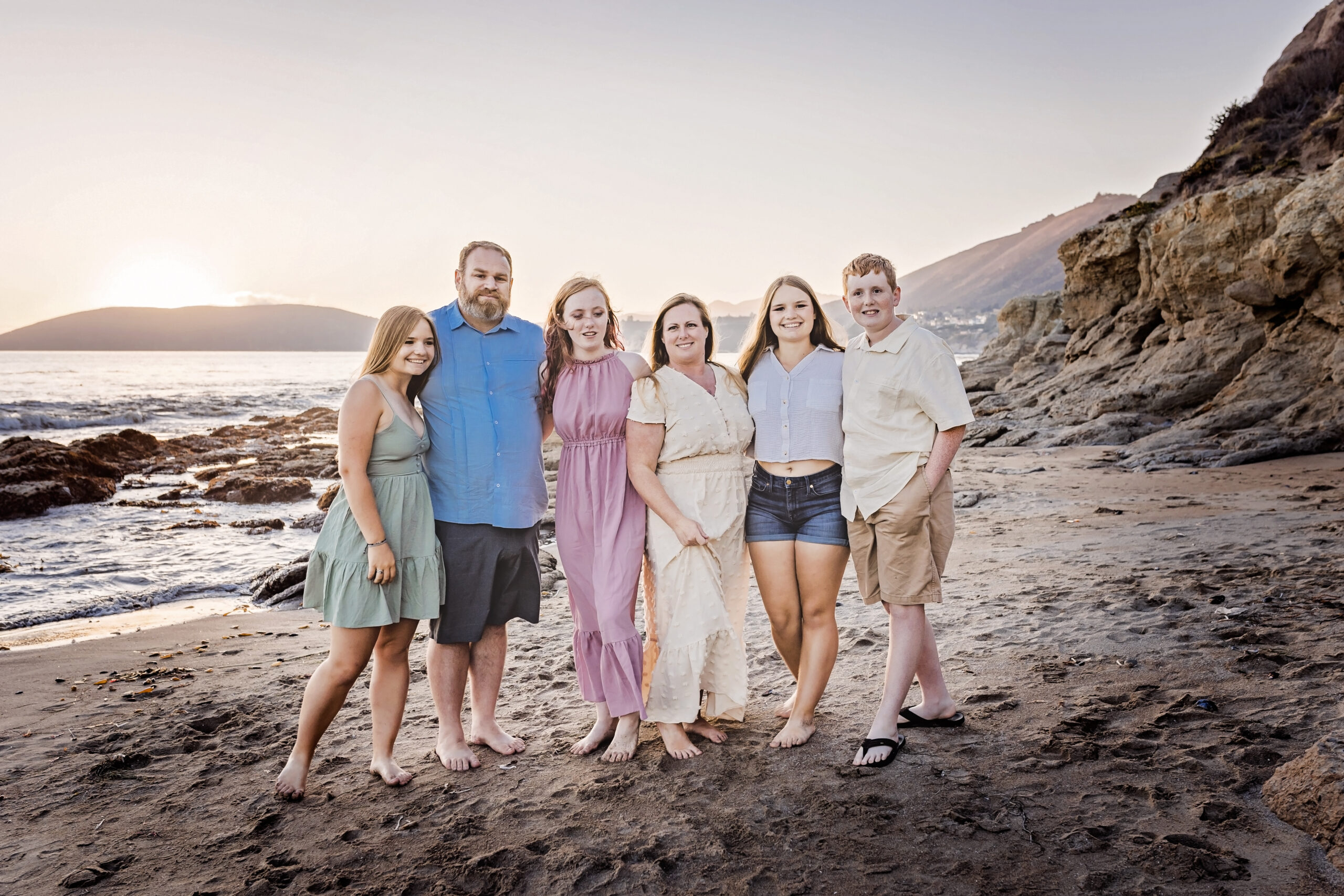 family of six standing together on the beach