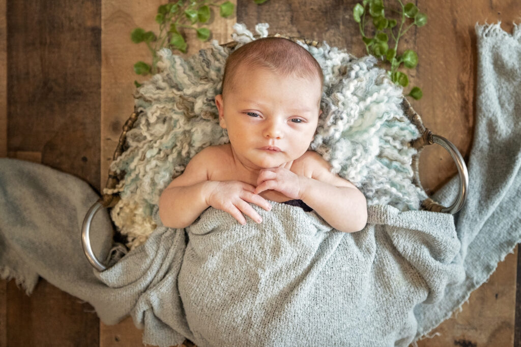 newborn boy with a light blue wrap