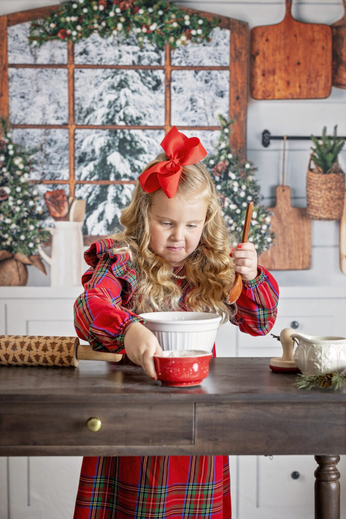 young girl mixing ingredients in a mixing bowl while in a Christmas kitchen