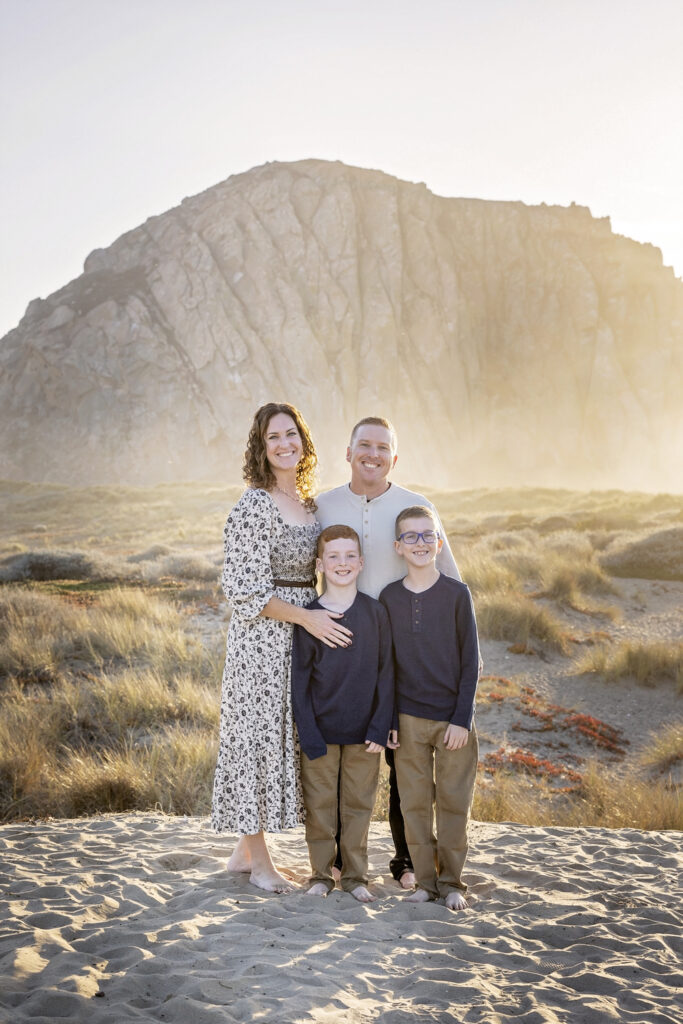 family of four standing together in front of Morro Rock