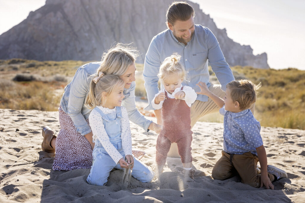family of five playing in the sand at Morro Rock