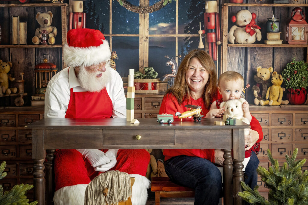 One year old girl playing with her mom and Santa Claus