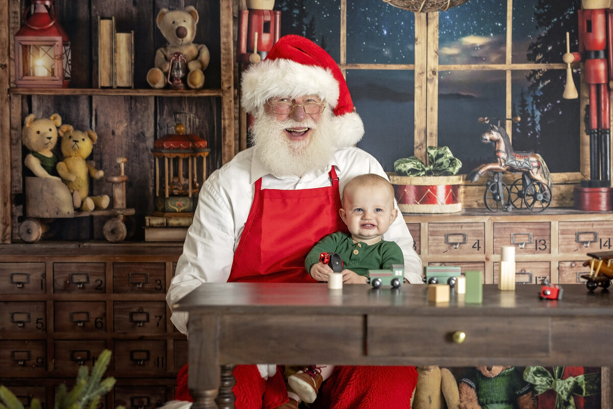 young girl playing with a toy airplane with Santa in his workshop